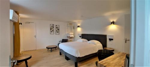 Hotel de Normandie في إيفرو: غرفة نوم بسرير ابيض كبير وطاولة