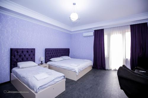 a hotel room with two beds and two lamps at Hotel Balcony in Kutaisi