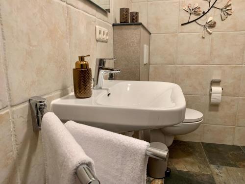 y baño con lavabo y aseo con toallas. en Königlich & modern See- und Zentrumsnah, en Prien am Chiemsee