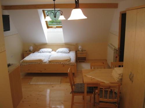 a bedroom with a bed and a dining table at Farmhouse Štiftar in Solčava