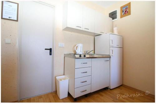 een keuken met een witte koelkast en een spoelbak bij Primosten Apartments in Primošten