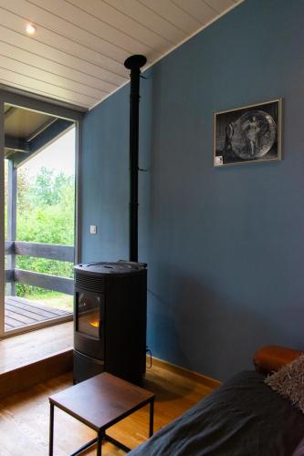 a living room with a wood stove in the corner at Le Chalet de Gaume in Virton