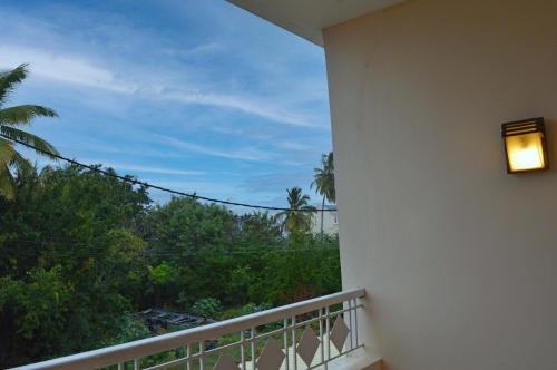 a room with a balcony with a view of trees at Maurer Loisirs Ltee in Trou aux Biches
