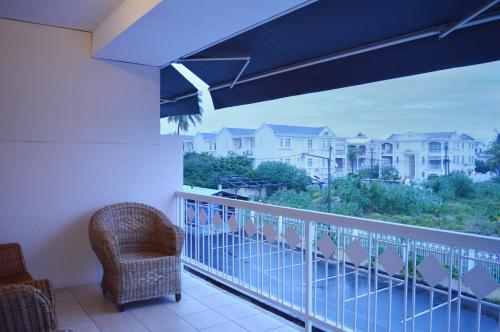 a balcony with a chair and a view of buildings at Maurer Loisirs Ltee in Trou aux Biches