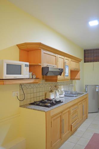a kitchen with a microwave and a stove top oven at Maurer Loisirs Ltee in Trou aux Biches