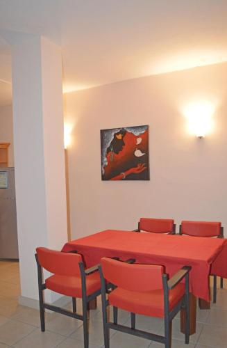a red table and chairs with a painting on the wall at Maurer Loisirs Ltee in Trou aux Biches