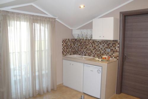 a kitchen with a sink and a window at Amaryllis Studios in Asprovalta