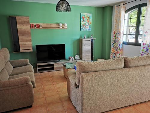 a living room with two couches and a flat screen tv at Cosy duplex in Agaete with WIFI in Agaete