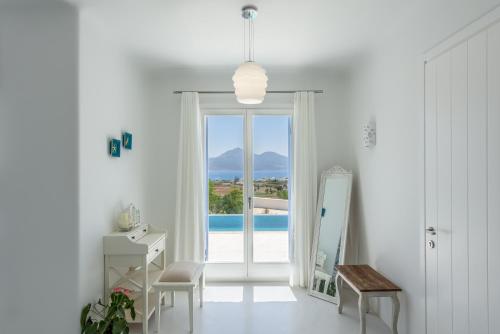 a white room with a door and a mirror at Blu Suites and Studios in Adamas