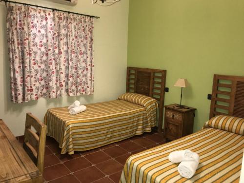 a hotel room with two beds and a window at La venta el Membrillo in Membrío
