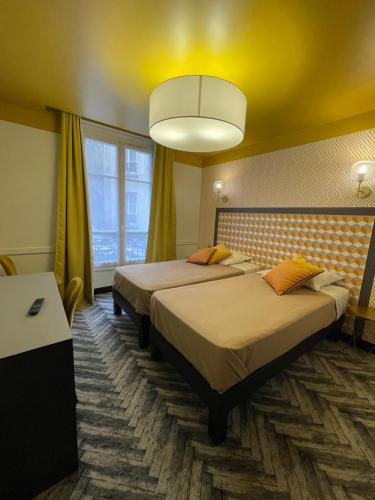パリにあるオテル ジェランドのベッド2台とシャンデリアが備わるホテルルームです。