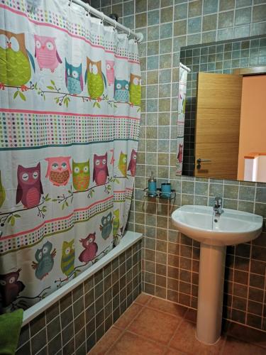 a bathroom with a shower curtain with owls and a sink at Cosy duplex in Agaete with WIFI in Agaete