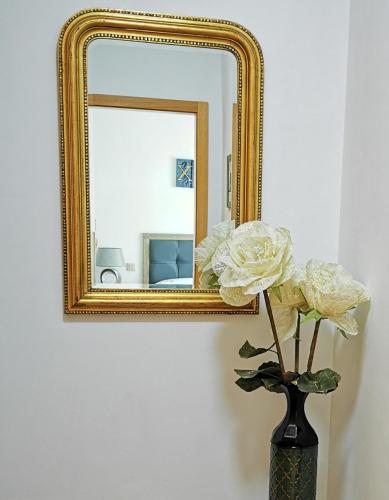 a vase with flowers in front of a mirror at Cosy duplex in Agaete with WIFI in Agaete