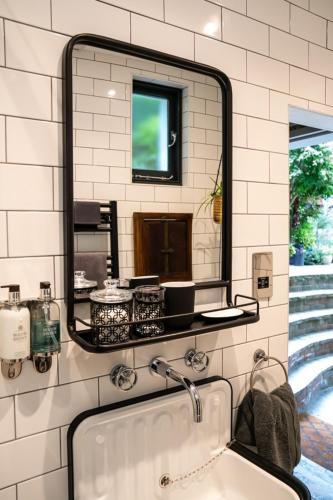 a bathroom with a sink and a large mirror at The Greenhouse in Portsmouth