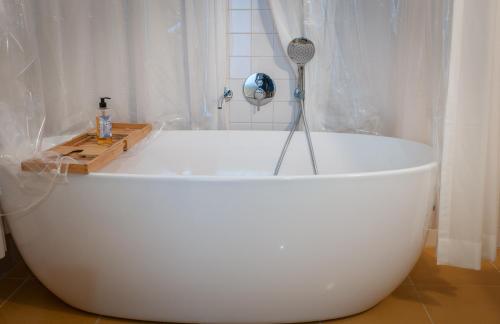 a white bath tub sitting in a bathroom at Cravo’s Heritage House in Pinhel