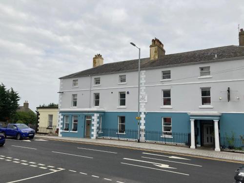 a white and blue building on the side of a street at Rooms@Mourne in Dundrum