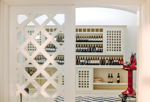 a wine cellar with a white cabinet with bottles of wine at San Montano Resort & Spa in Ischia