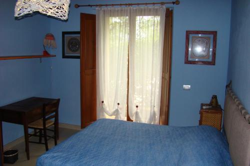una camera con letto, finestra e scrivania di Casa Natura a San Gimignano