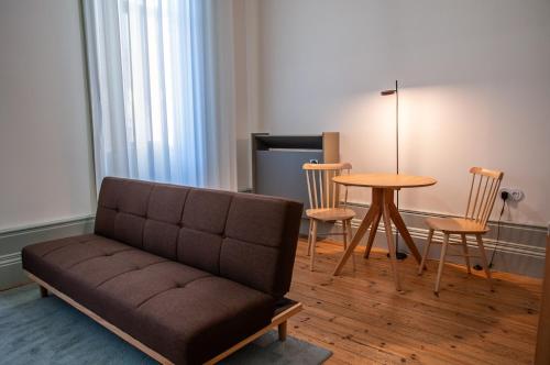 a living room with a couch and a table and chairs at Cravo’s Heritage House in Pinhel