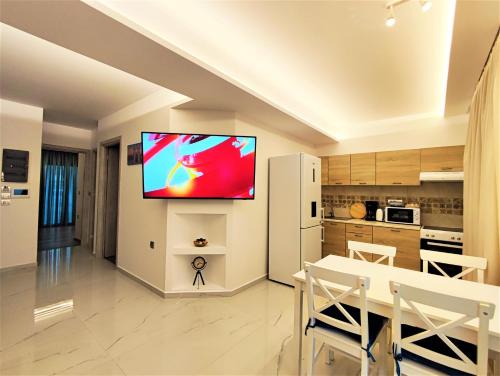 a kitchen and dining room with a television on a wall at Villa Pavlina in Ixia