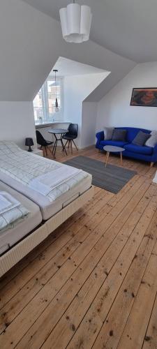 een slaapkamer met een groot bed en een houten vloer bij Korsør Room in Korsør