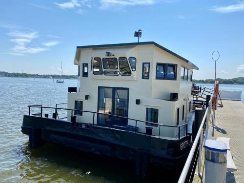 Un petit bateau est amarré à un quai. dans l'établissement Island-dreams Hausboote Groth & Rhin, à Schleswig