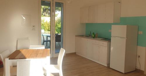 uma cozinha com uma mesa e um frigorífico branco em Molto Benissimo em Otranto