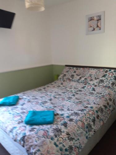 a bed with two blue pillows on top of it at Delamere Hotel in Blackpool