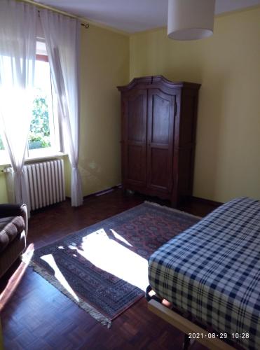 a bedroom with a bed and a cabinet and a window at Il Barucin in Villar San Costanzo