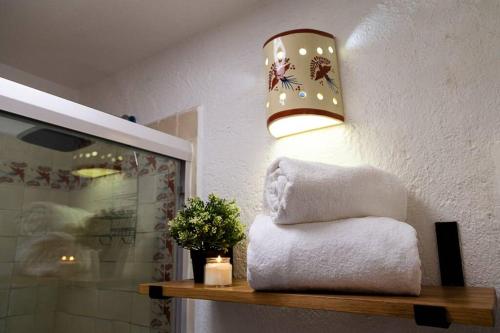 a bathroom with a pile of towels and a lamp at Casa Aurora, estilo rústico-moderno, Guanajuato in Guanajuato