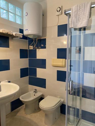 a blue and white bathroom with a toilet and a sink at Il Pepe Rosa in Posada