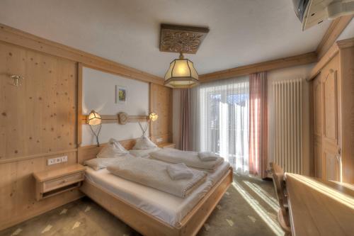 a bedroom with a bed and a large window at Hotel Rezia in La Villa