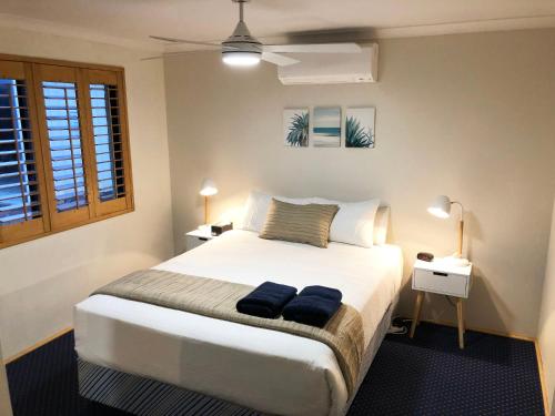 ein Schlafzimmer mit einem Bett mit zwei blauen Handtüchern darauf in der Unterkunft Observatory Guesthouse - Adults Only in Busselton
