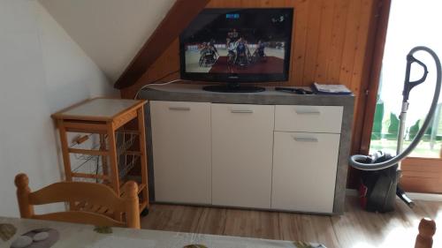 a living room with a tv on top of a cabinet at Duplex Métabief in Métabief