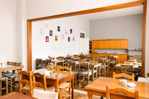 une salle à manger avec des tables et des chaises en bois dans l'établissement Pousada Vista do Lago - HOSTEL, à Gramado