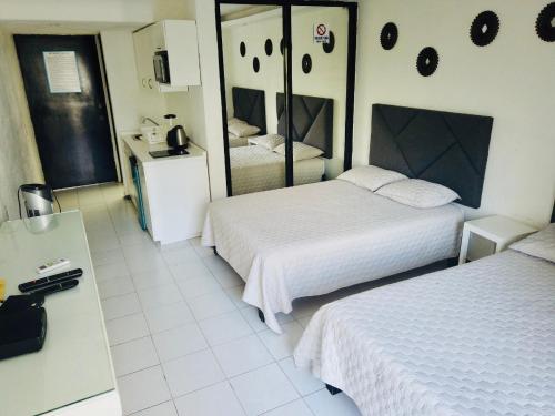 een hotelkamer met twee bedden en een spiegel bij SKY Acapulco Y condominio mediterrane in Acapulco