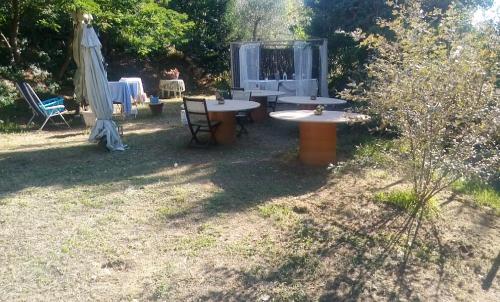 a patio with tables and chairs in a yard at Casolare Toscano in Lorenzana