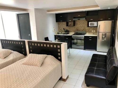a bedroom with a bed and a kitchen at Acapulco suites Y condominio Mediterrane in Acapulco