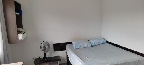 um pequeno quarto com uma cama e uma ventoinha em FARO FINO 106 ORLANDO em Goiânia