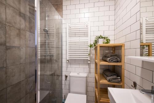 a bathroom with a toilet and a shower and a sink at Playa Zurriola in San Sebastián