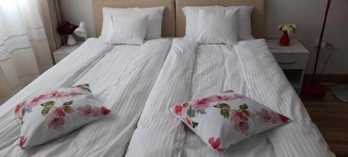 Duas almofadas numa cama branca com lençóis brancos em Klara Studio Apartman em Split