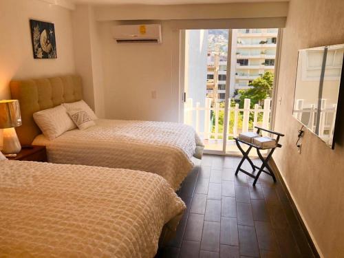 En eller flere senge i et værelse på Acapulco Hotel y suites mediterrane