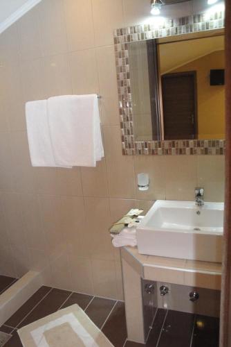 a bathroom with a sink and a mirror at Amaryllis Studios in Asprovalta