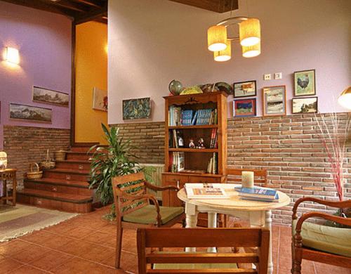 Habitación con mesa, sillas y pared de ladrillo. en La Ablaneda, en Soto de Cangas
