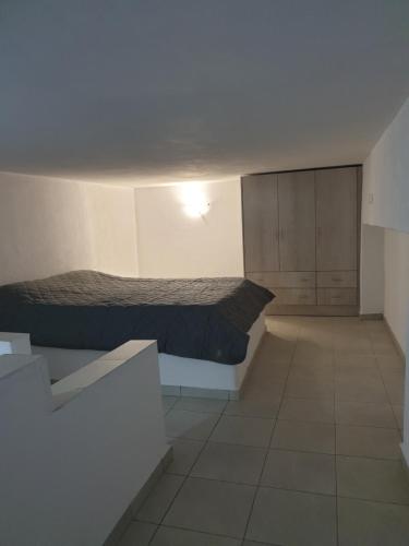a small bedroom with a bed and a cabinet at Porto Castello in Fira