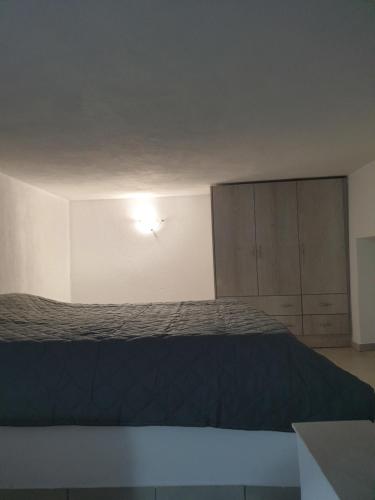 a bedroom with a bed and a light on the wall at Porto Castello in Fira