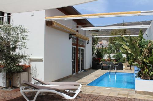 een huis met een zwembad en een patio bij CASA EL OLIVO, TENERIFE in Valle de San Lorenzo