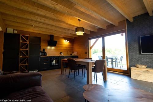 a kitchen and dining room with a table and chairs at Les Jardins du Hérisson Chalet 2 in Bonlieu
