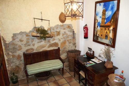 um quarto com uma cadeira, uma secretária e um espelho em Casa Rural El Huerto del Trucho em Oliete