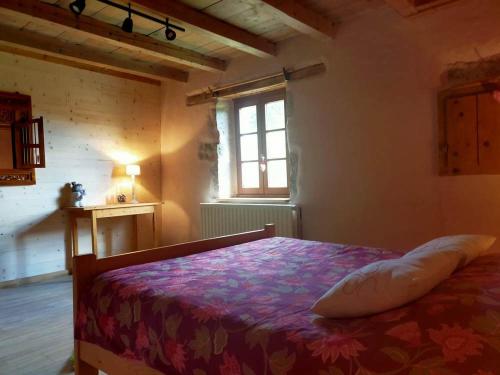 a bedroom with a bed in a room with a window at Refuge Sous La Joux in Les Moussières